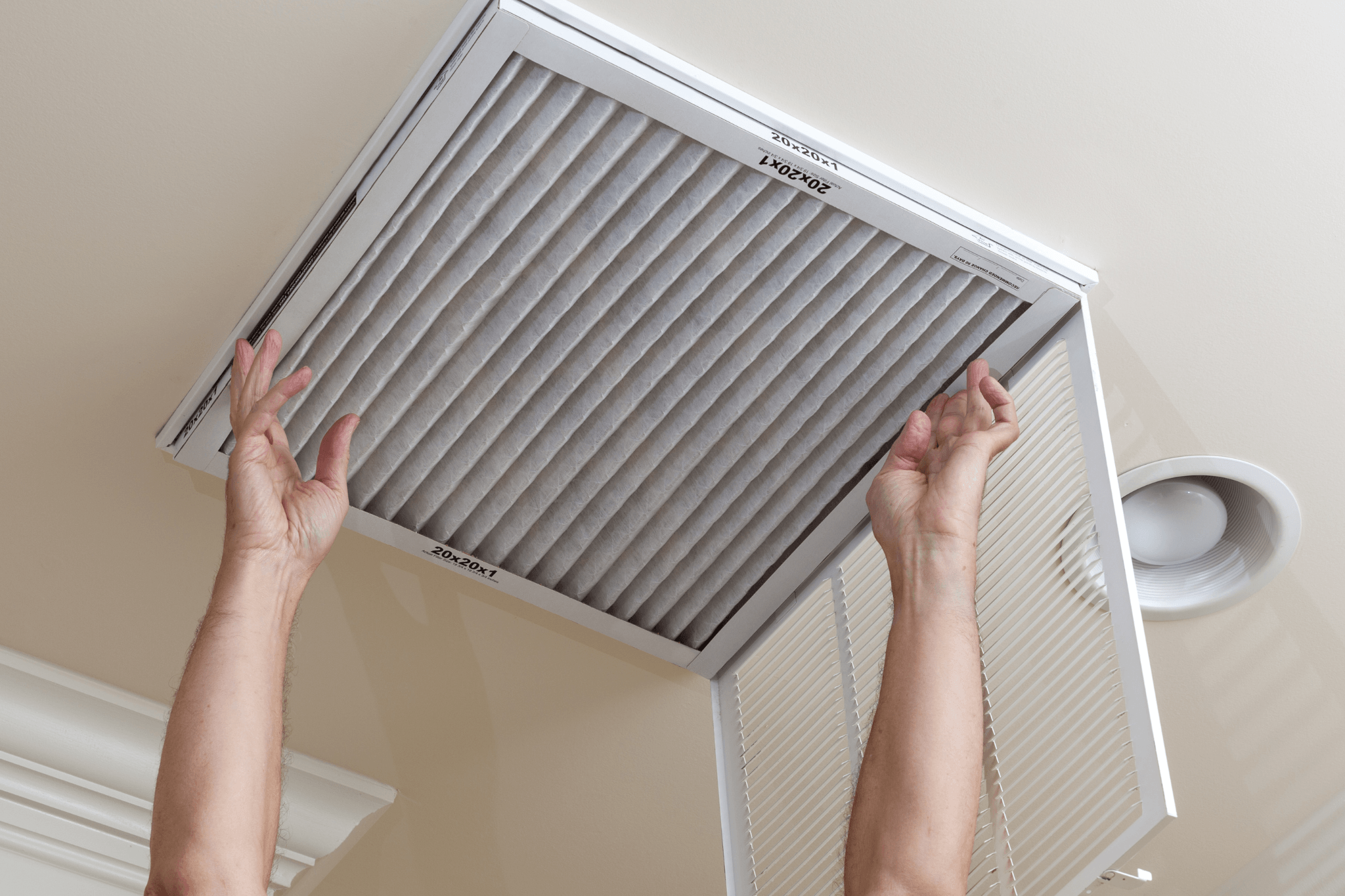 HVAC apprentice replacing an air filter during on-the-job training with a licensed San Diego contractor