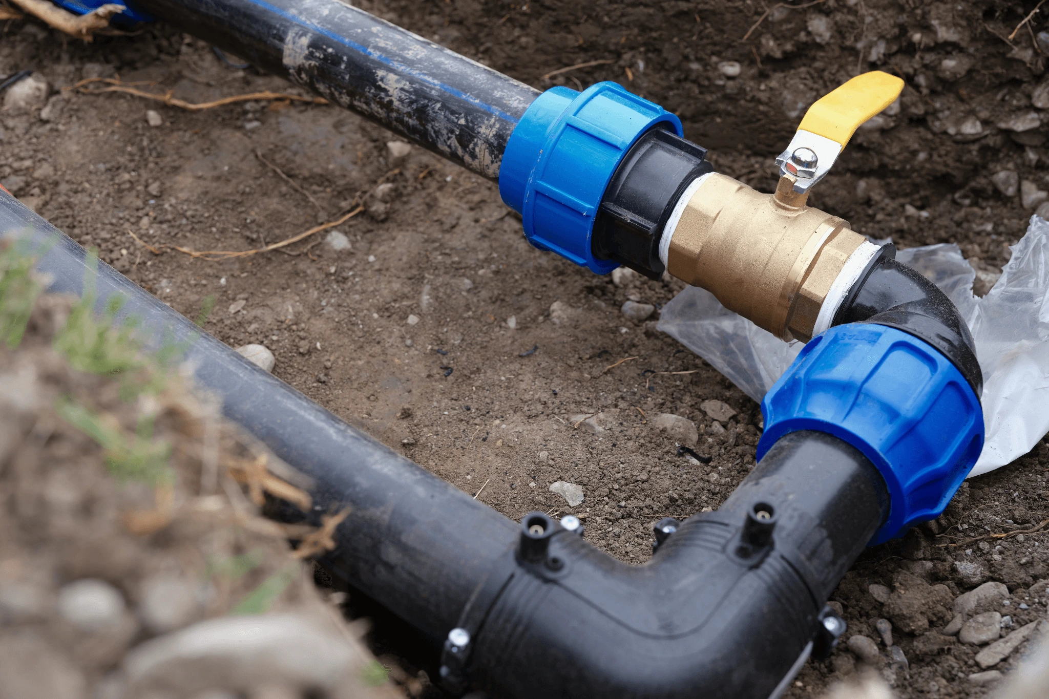 Underground pipe valve inspected as part of hands-on plumbing training relevant to backflow assemblies